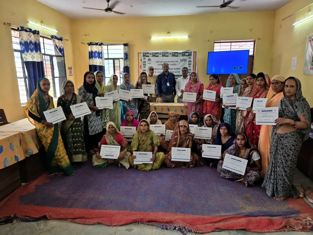 SHG women holding completion certificates at the NABARD-sponsored digital e-commerce marketing training in Khanua, Bharatpur, June 2026.